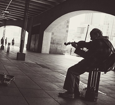 an old man playing violin in the street